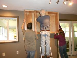 My wife and I holding the cabinets while my father screwed them in place